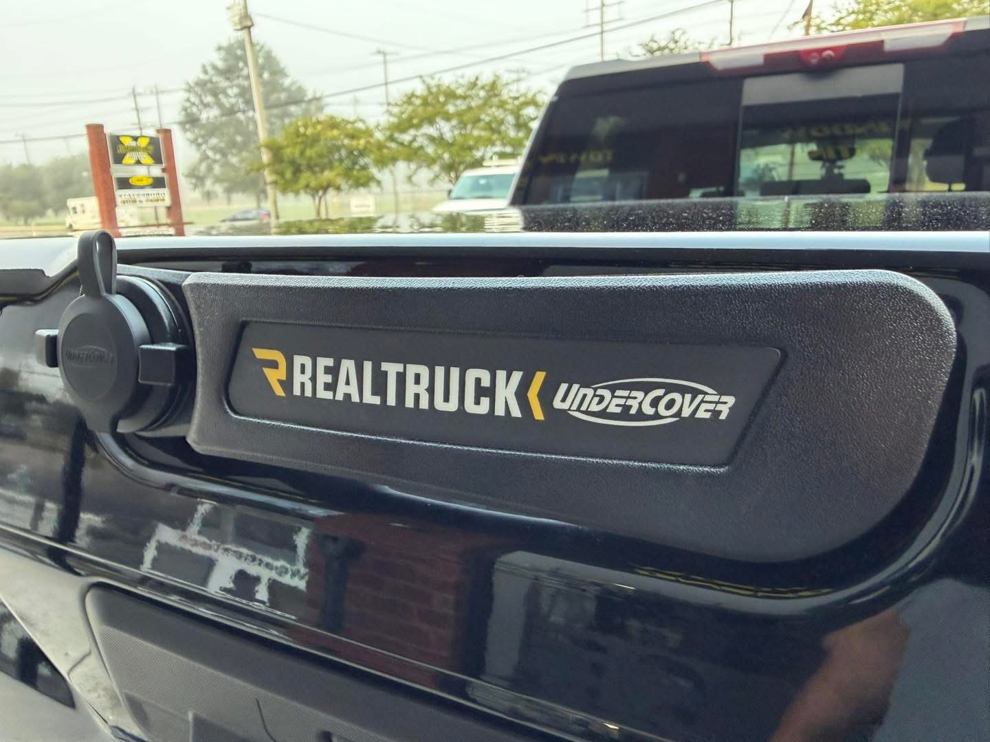 Close-up of an UnderCover truck bed cover latch on a tailgate